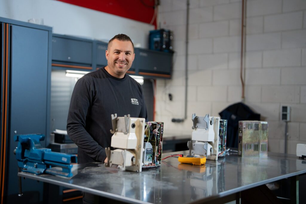 Jan-Willem, weegspecialist bij STC Food Solutions, aan de werkbank met onderdelen van een multihead weger
